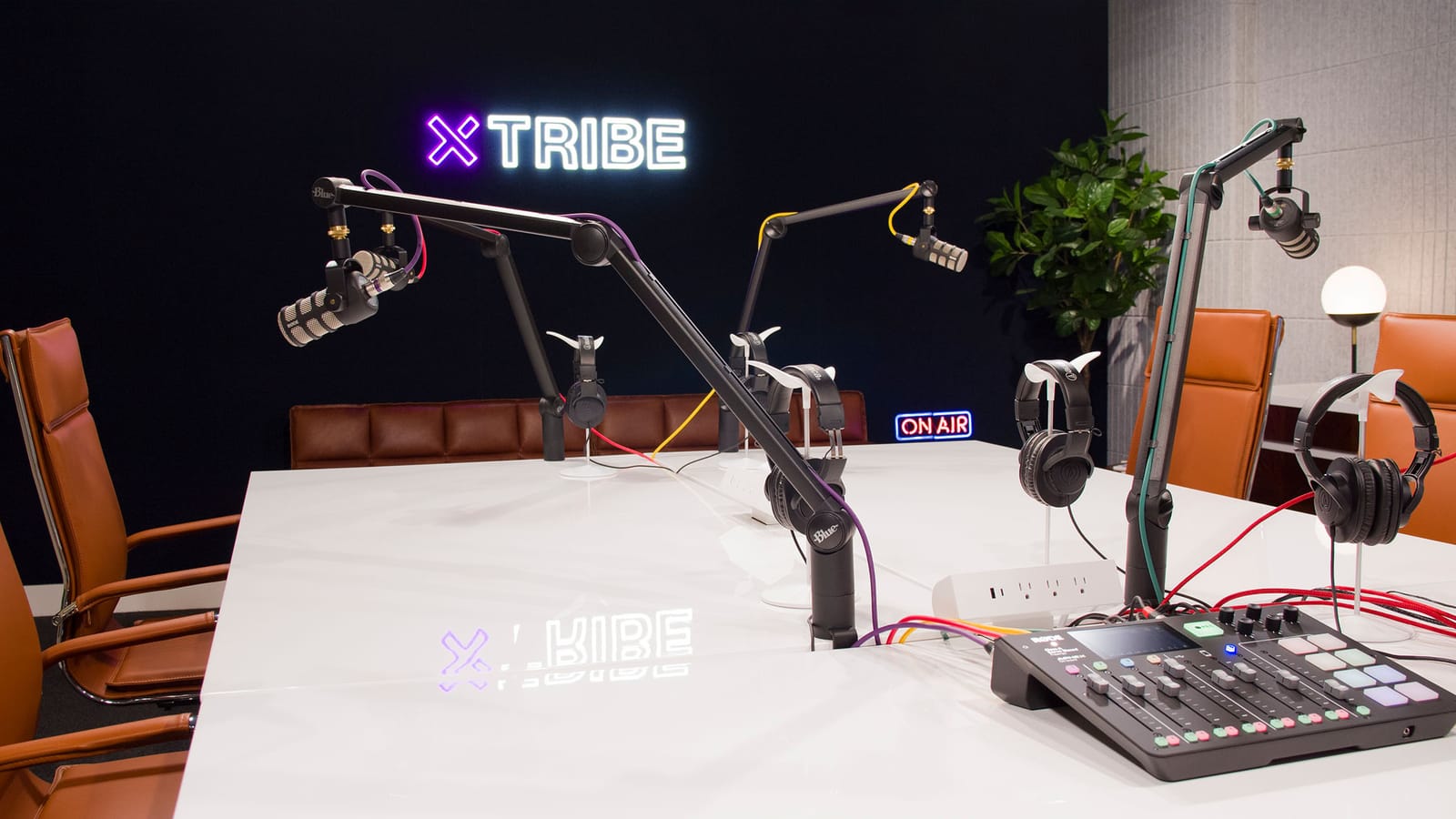 Podcast desk with neon xTribe sign